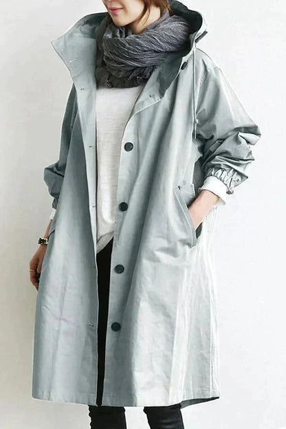 Women’s raincoat in light grey with oversized hood and button-front, knee-length.