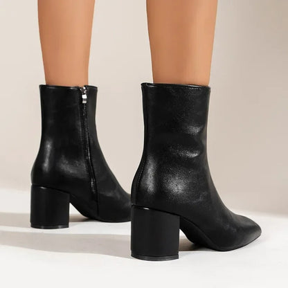 Black ankle boots with side zipper and mid block heel, smooth finish, pointed toe.