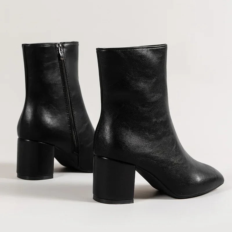 Black ankle boots with side zipper and mid block heel, textured shine, pointed toe.