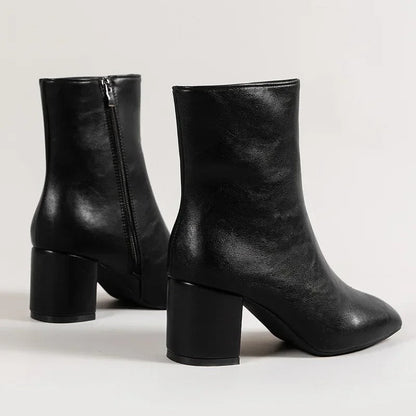 Black ankle boots with side zipper and mid block heel, textured shine, pointed toe.