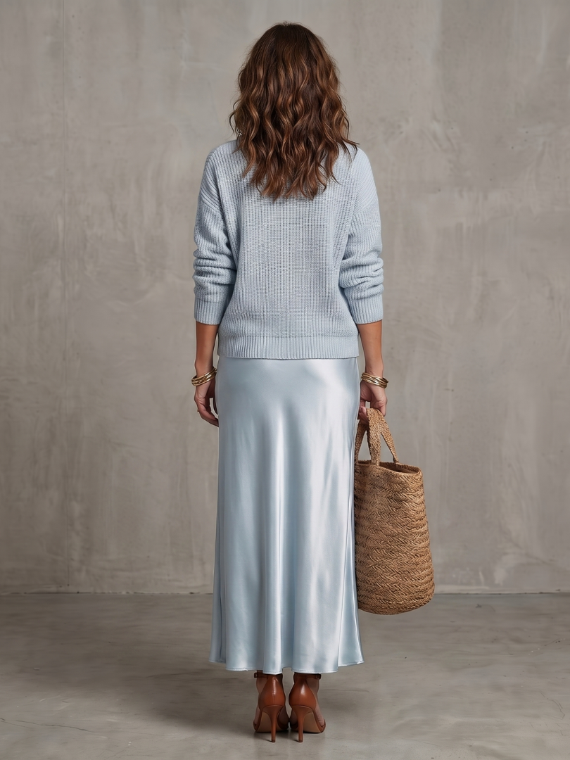 Women's sky blue knit sweater and satin bias skirt set, back view