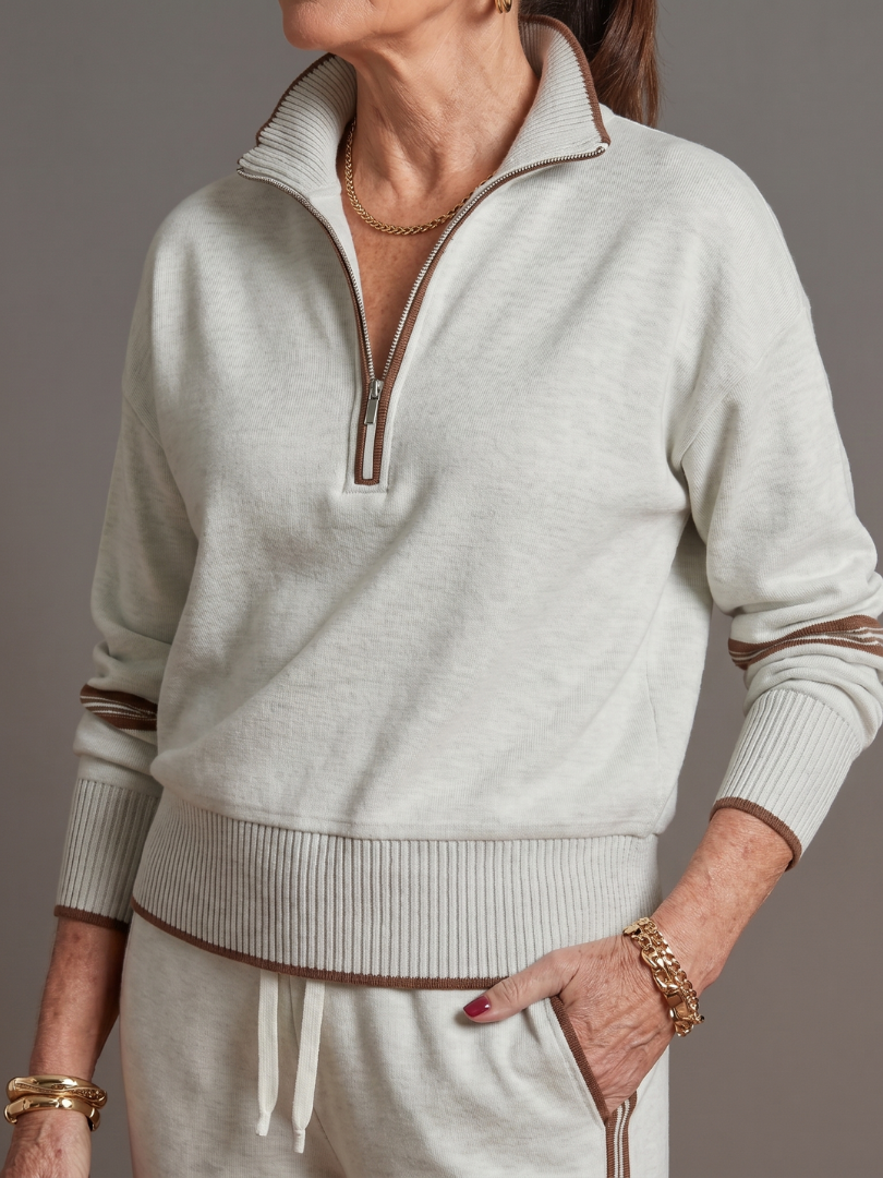 Light gray zip-neck knit top with white trim, ribbed cuffs; drawstring jogger pants