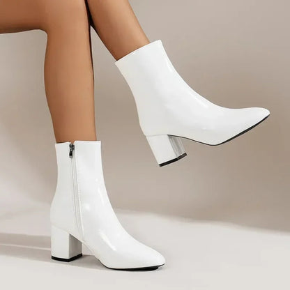 White ankle boots with side zipper and mid block heel, sleek pointed toe, low shaft.
