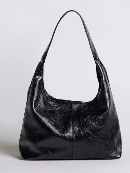 Distressed vegan leather tote bag in black with top handles and slouchy shape