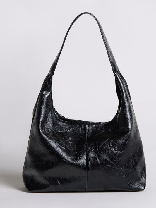 Distressed vegan leather tote bag in black with top handles and slouchy shape