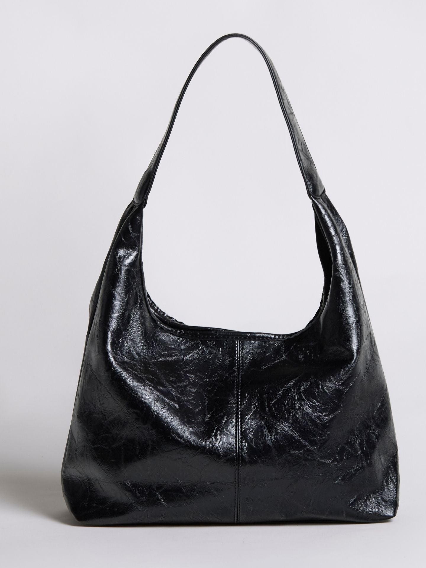 Black distressed vegan leather tote bag with wide handles and a slouchy silhouette.