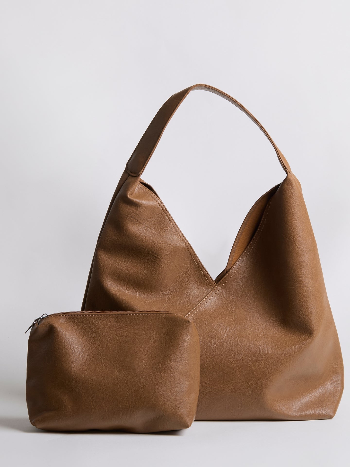 Tan leather shoulder bag with matching pouch and short top handles.
