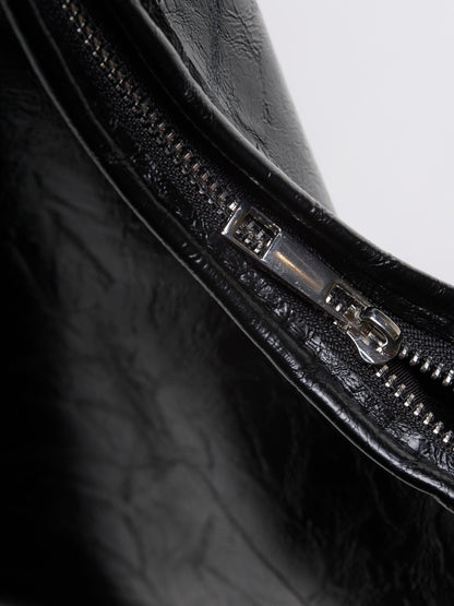 Distressed vegan leather tote bag close-up of black zipper and stitched trim