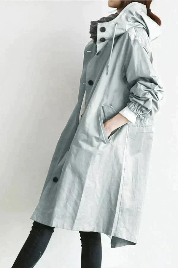Women’s raincoat in light grey with oversized hood, button-front and roomy sleeves.