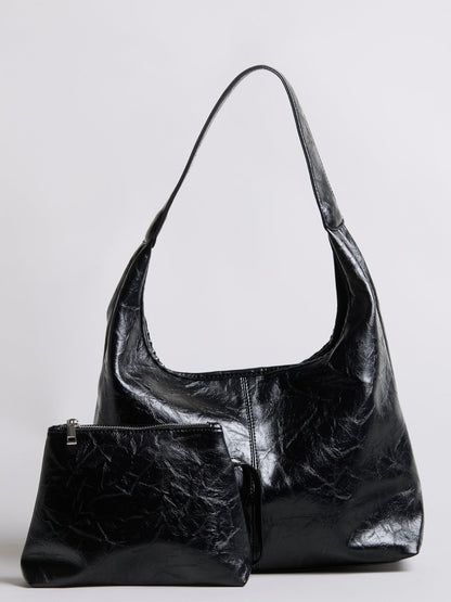 Distressed vegan leather tote bag in black with large top opening and side pocket
