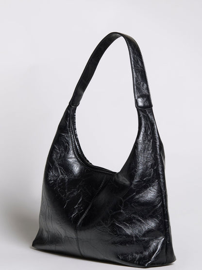 Black distressed vegan leather hobo tote with wide opening and curved shoulders