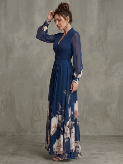 Navy pleated maxi dress with sheer sleeves and floral hem, ruched waist and V-neck