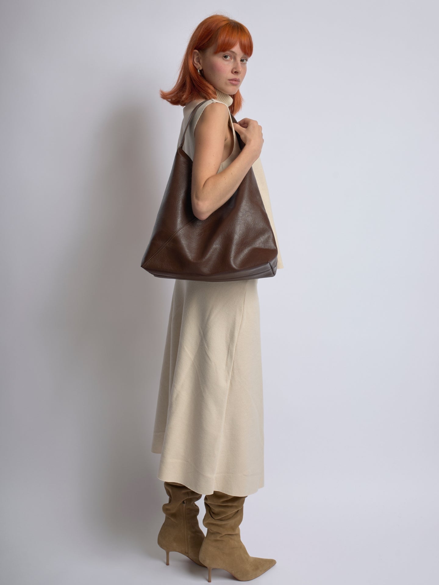 Brown leather shoulder bag, side view with soft slouchy shape and top handle straps