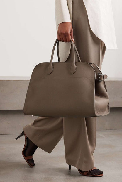 Brown suede tote handbag with dual handles and side zip pocket detail