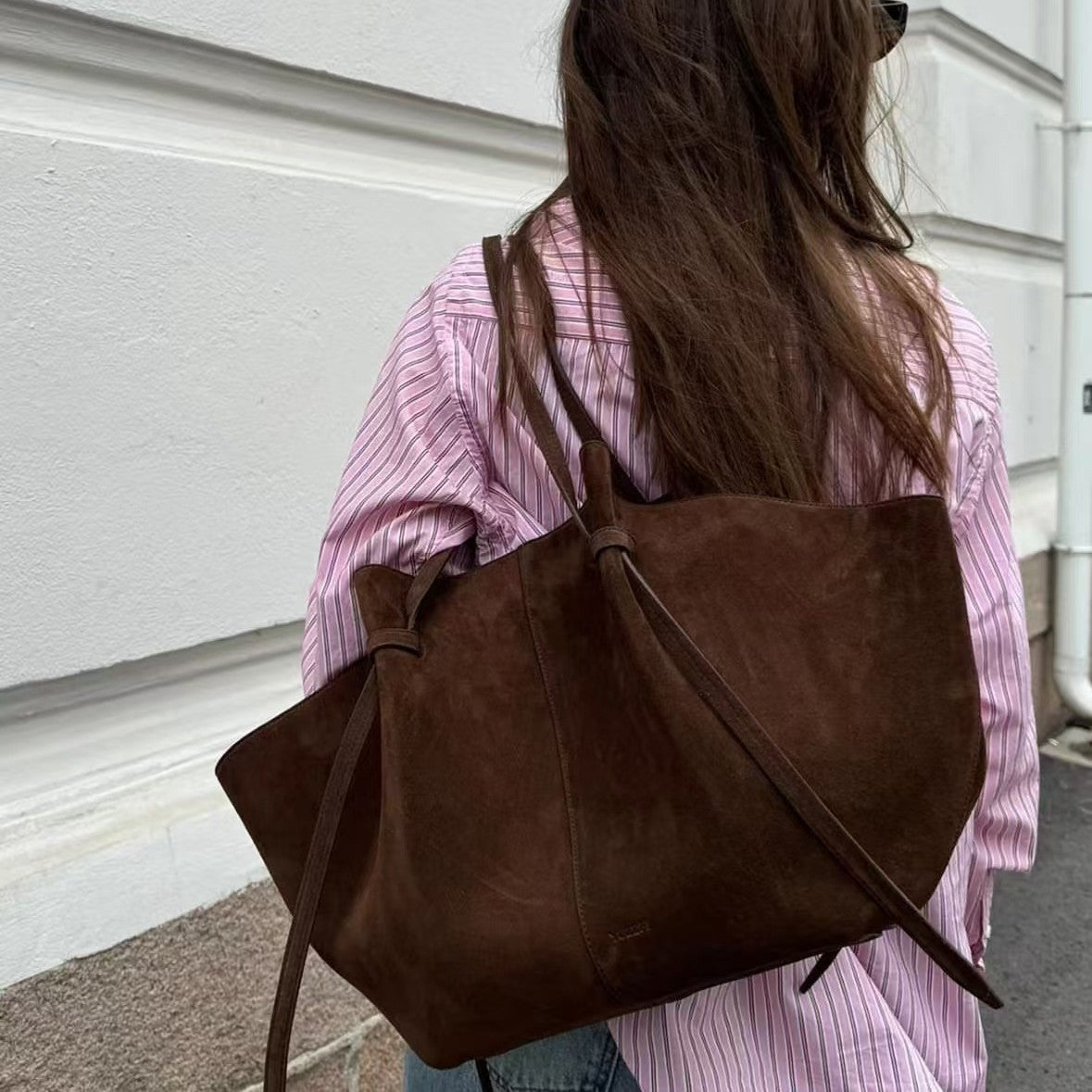 Dark brown suede tote bag with dual handles and long shoulder strap