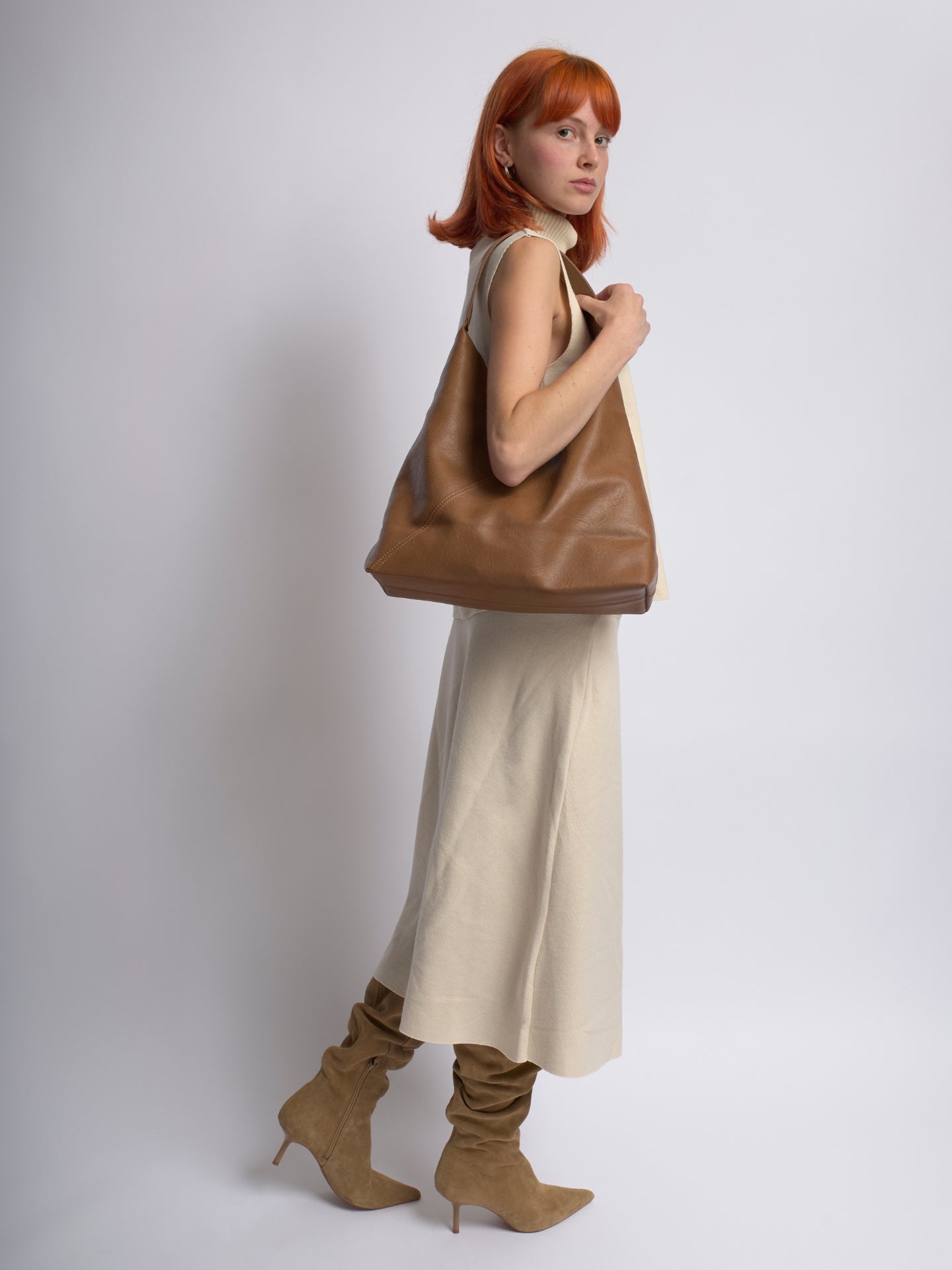 Tan leather shoulder bag with slouchy silhouette and top handle straps