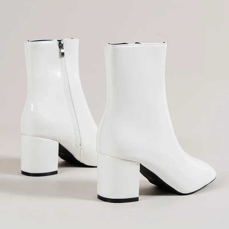 White ankle boots with side zipper and chunky mid block heel, rounded pointed toe.