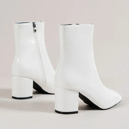 White ankle boots with side zipper and chunky mid block heel, rounded pointed toe.