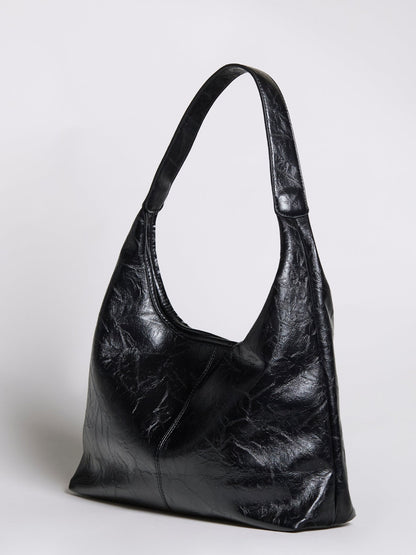 Black distressed vegan leather tote bag with curved handles and open top