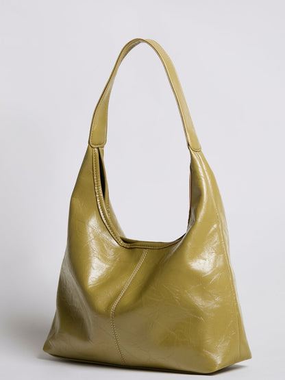 Distressed vegan leather tote bag in olive gold with top handles and curved opening