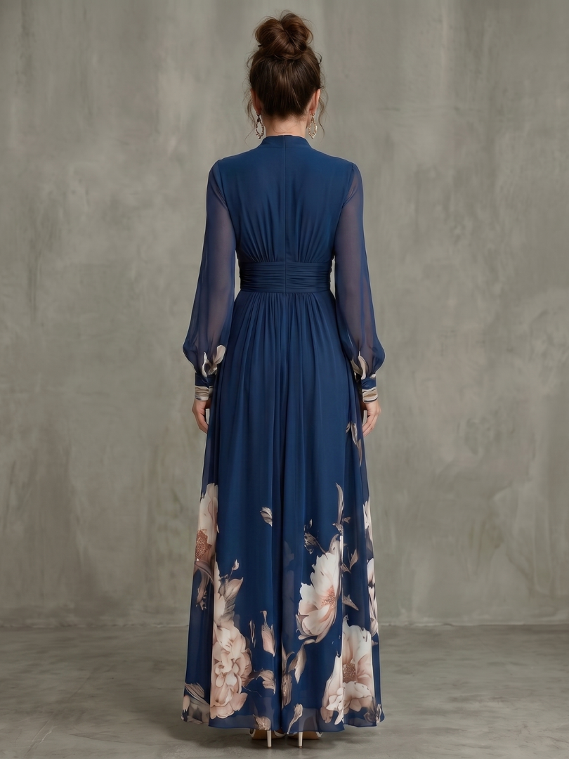 Back view of navy maxi dress with pleated waist and sheer sleeves, floral hem