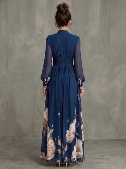 Back view of navy maxi dress with pleated waist and sheer sleeves, floral hem