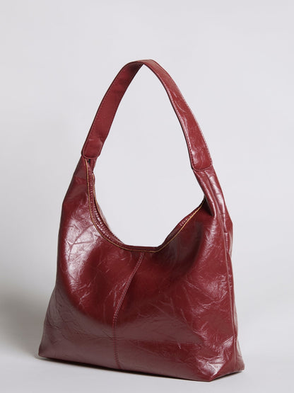 Distressed vegan leather tote bag in burgundy red with curved top handles