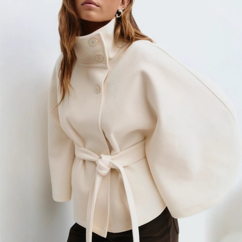 Women’s high-collar cape coat, off-white, button front with waist tie and cape sleeves.