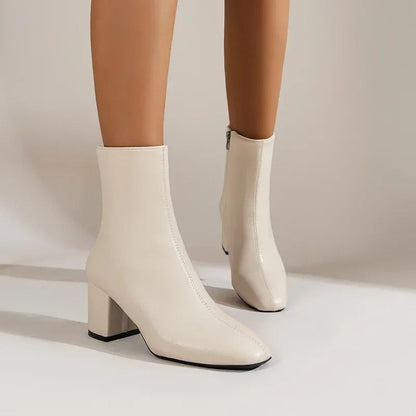 Cream beige ankle boots with side zipper and mid block heel, pointed toe and short shaft.