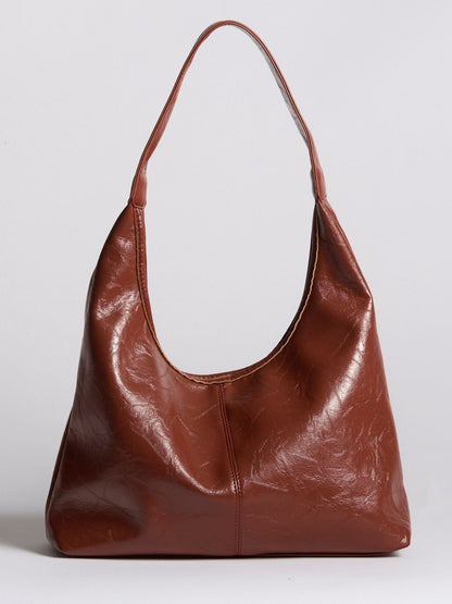 Rust brown distressed vegan leather tote bag with wide handles and soft slouch form.