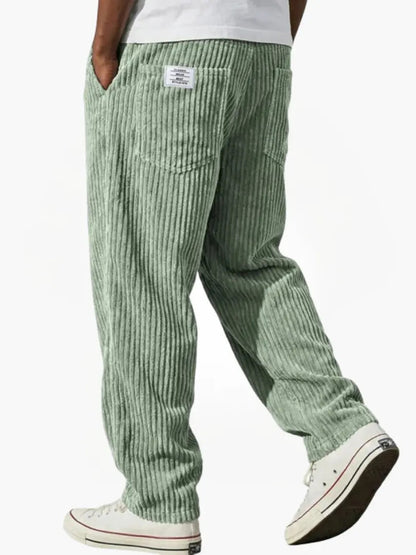 Wide-leg men's trousers with pockets in green vertical cord texture.