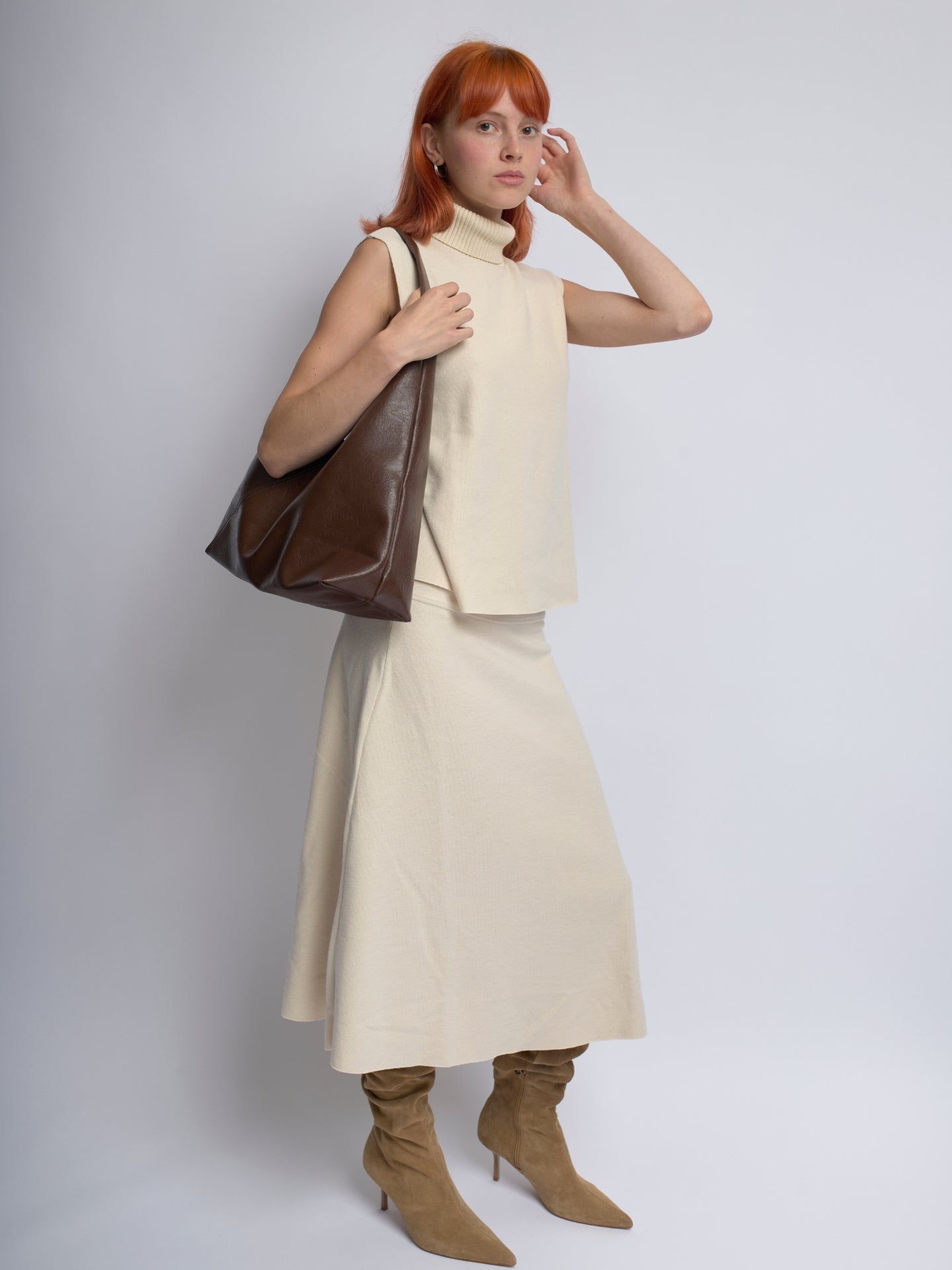 Brown leather shoulder bag with slouchy design and top handle straps
