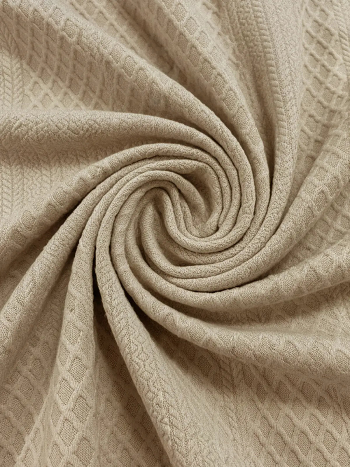 Beige cable knit fabric close-up with diamond texture pattern