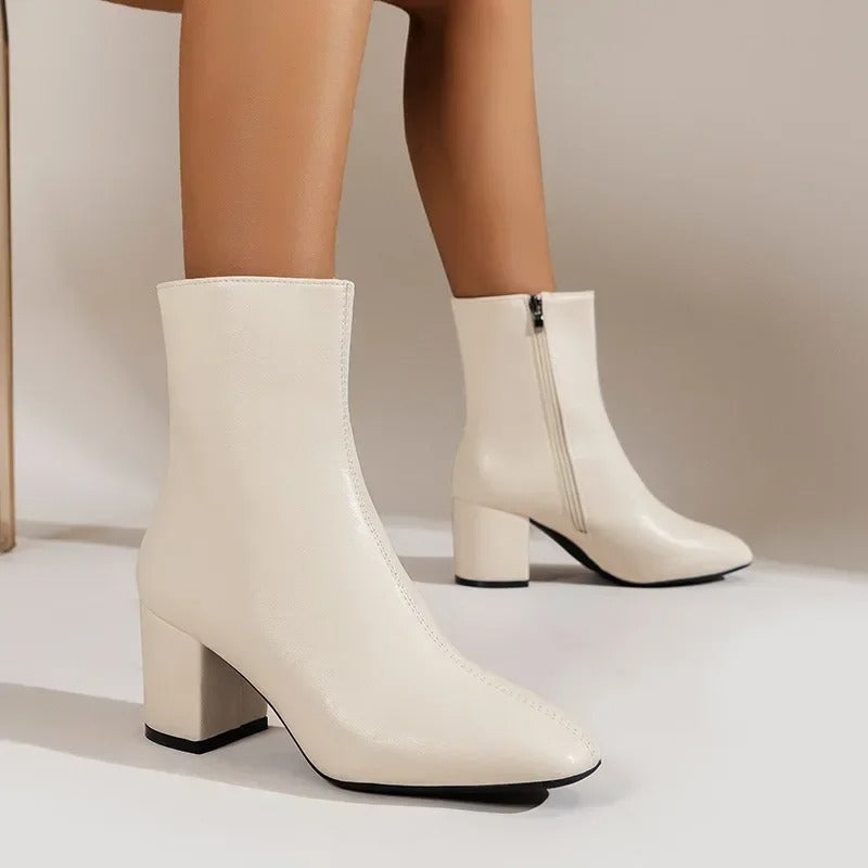 Light beige ankle boots with side zipper and mid block heel, pointed toe design.