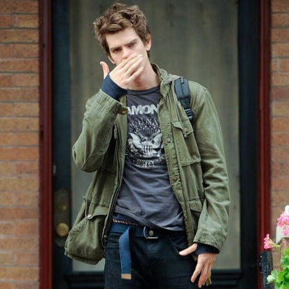 Men's olive green field jacket with hood folded back, worn over dark T-shirt