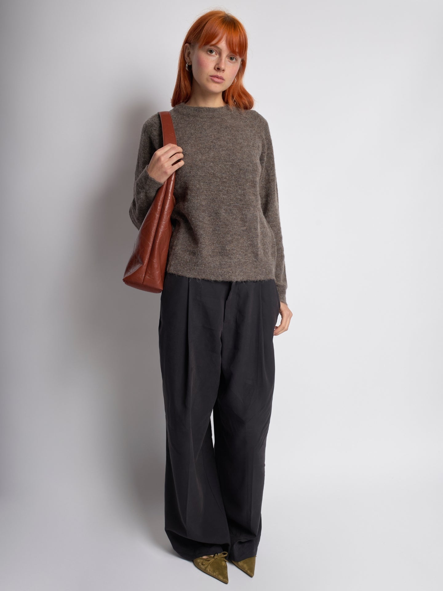 Brown distressed vegan leather tote bag with side strap and curved shoulder handles.