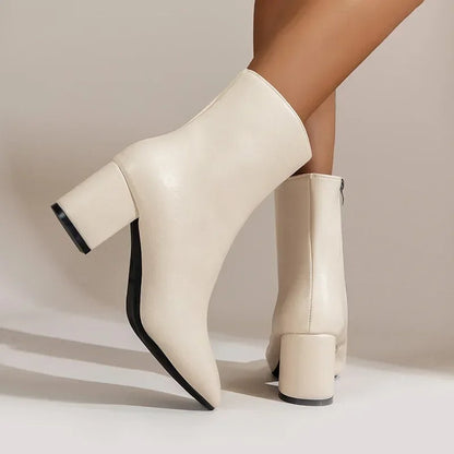 Light beige ankle boots with side zipper, mid block heel, glossy finish, pointed toe.