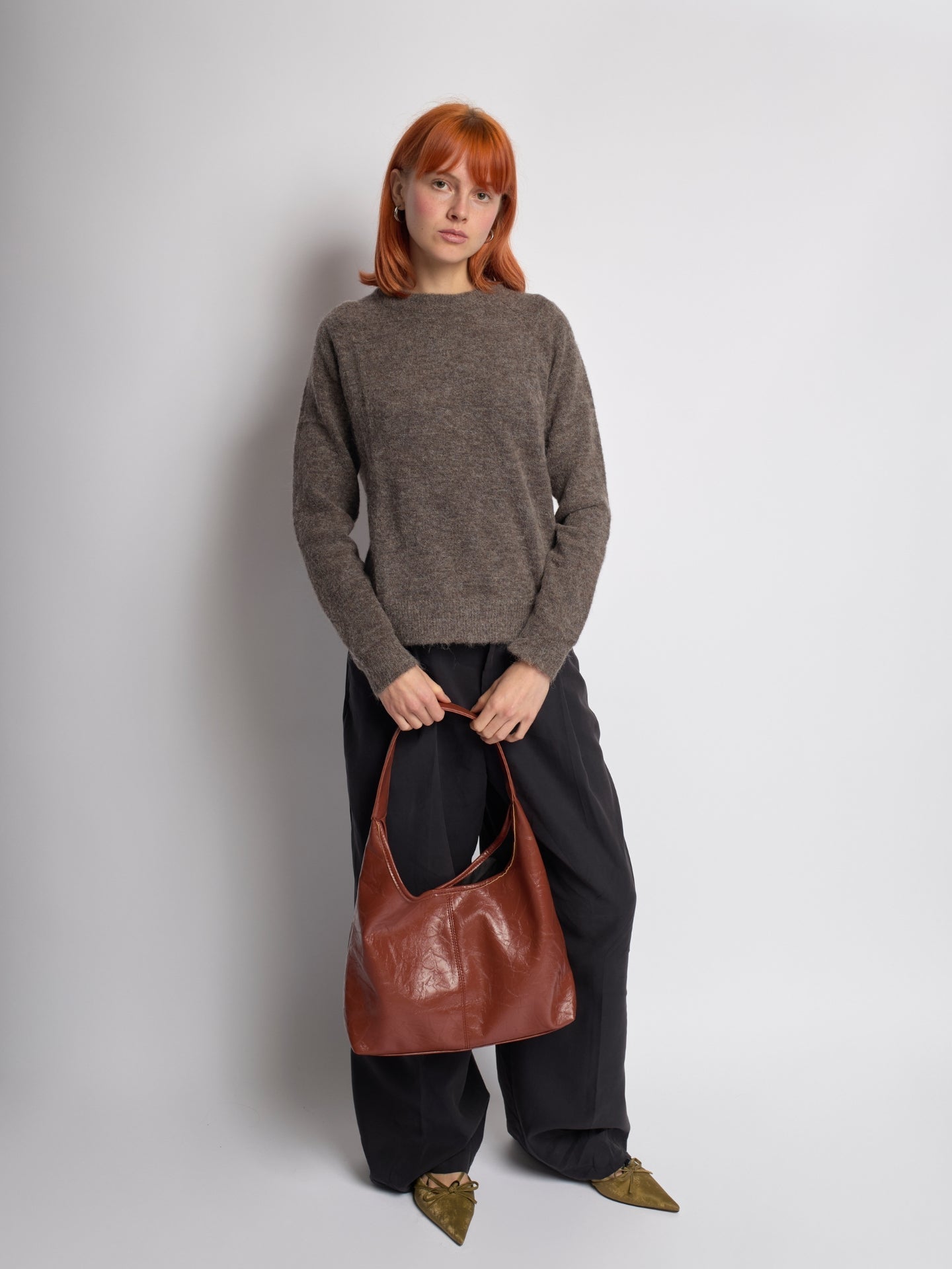 Distressed vegan leather tote bag in brown with top handles and side slit detail