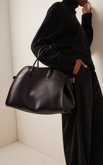 Black suede handbag with top handles and center seam detail