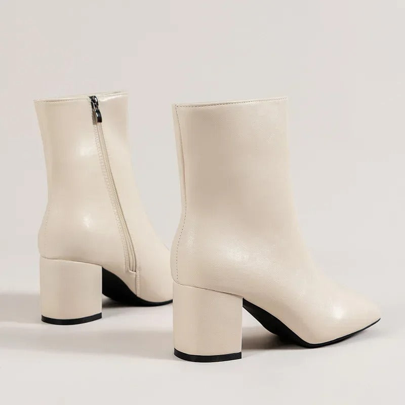Beige ankle boots with side zipper and mid block heel, square collar and pointed toe.