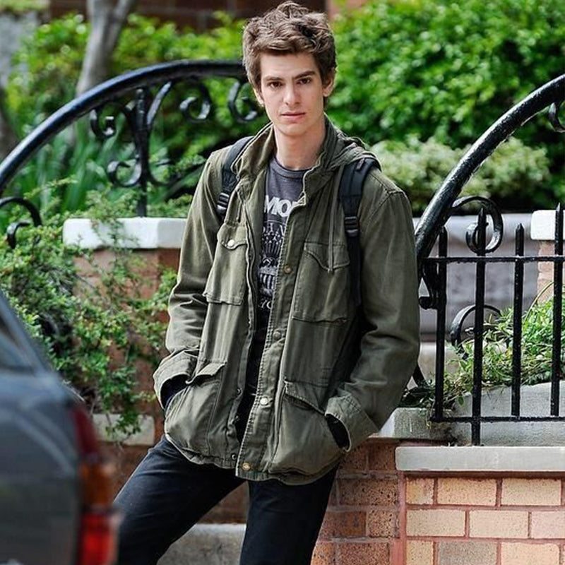 Olive green field jacket with multiple utility pockets and hood, worn with backpack