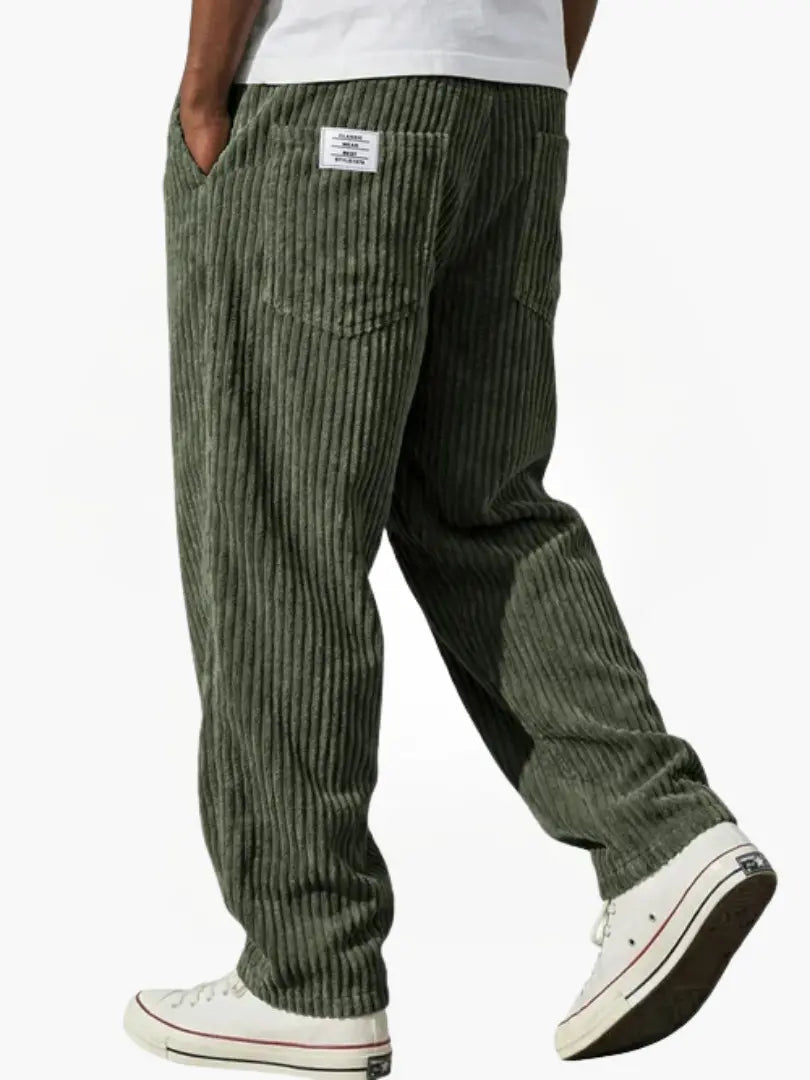 Wide-leg men's trousers with pockets in dark green vertical cord texture.