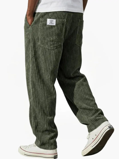 Wide-leg men's trousers with pockets in dark green vertical cord texture.