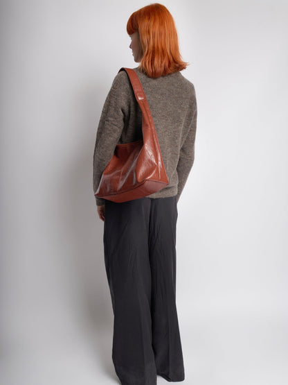 Brown distressed vegan leather tote bag shown from the back with top handles.