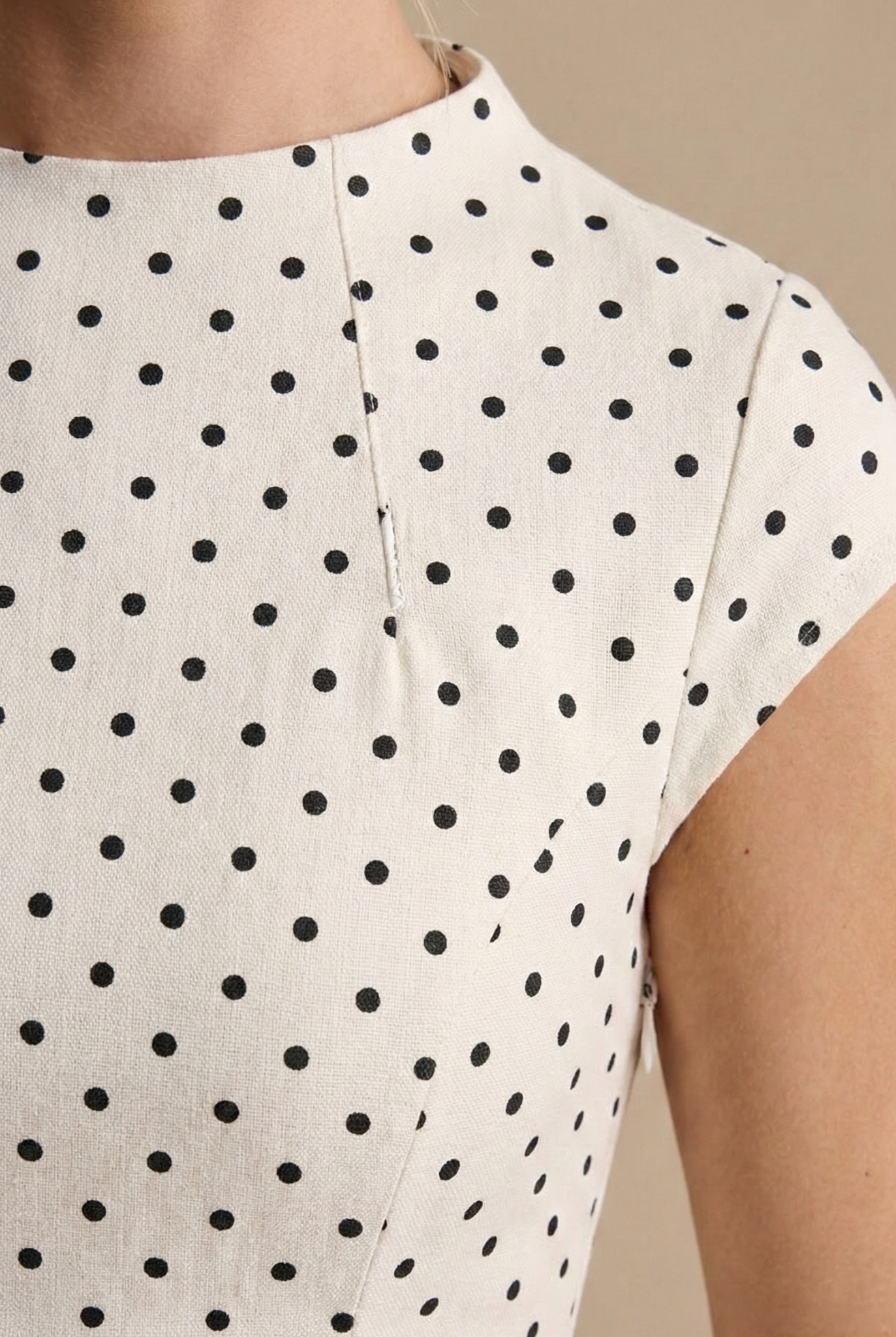 White fabric with black polka dot pattern and visible side seam detail