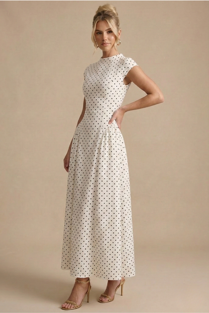White polka dot maxi dress with high neckline, cap sleeves, and gathered skirt
