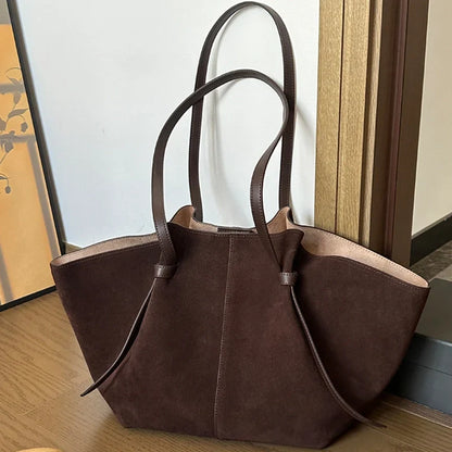 Dark brown suede tote bag with dual handles and front seam detail