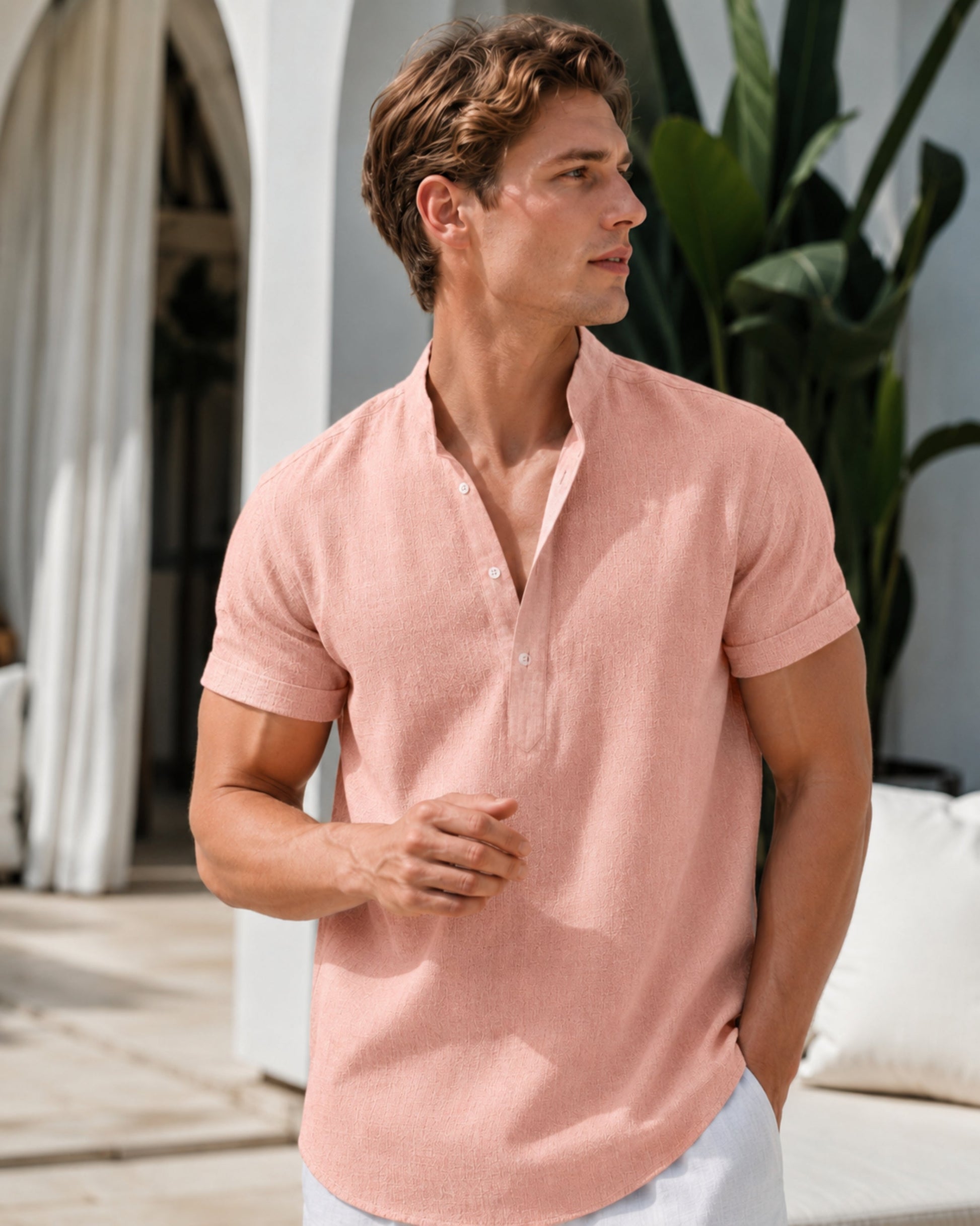 Men's pink linen henley shirt with short sleeves and buttoned neckline.