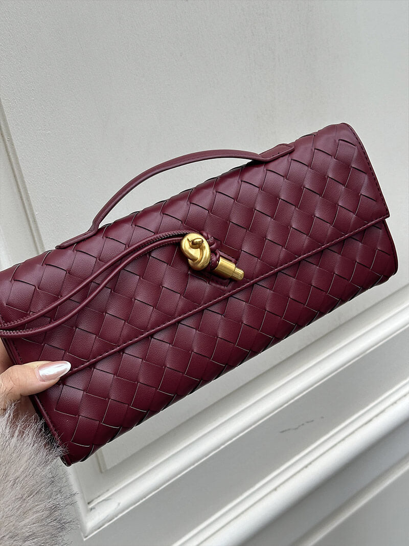 Burgundy woven vegan leather clutch with gold clasp and long shoulder strap