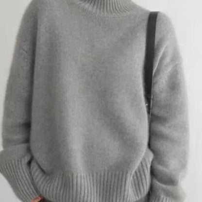 Grey roll-neck cashmere jumper close-up, ribbed hem and knit texture